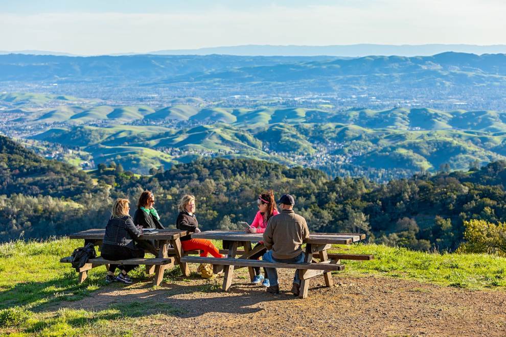 people sitting at tables on a hillside